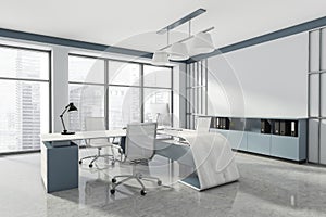 Head of company`s office interior with table and desktop computer, shelf with folders, white armchairs. Mockup copy space wall.