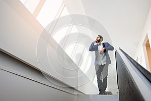 The head of the company stands in a white office and looks out the window, a successful businessman finding employment in a large