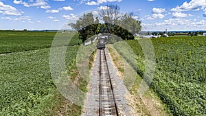 Head on Drone View of a Steam Passenger Train Approaching on a single Track