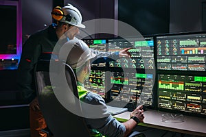 Head engineer and factory operator following product process on factory uses SCADA system and industry 4.0. Two operators controll