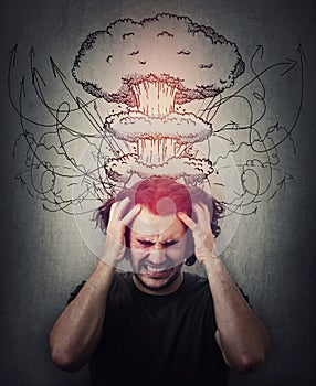 Head explosion metaphor. Bewildered man messing up and pulling his hair,  eyes closed screaming and clenching teeth. Suffering