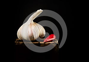 Head of garlic with red pepper on a dark background