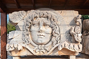 Marble tablet with ancient stone carving of Medusa Head. photo