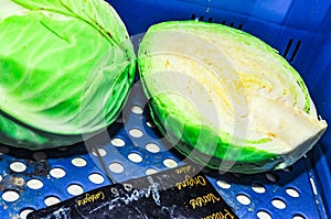 Head of green cabbage, sliced in half to expose the, yellow, delicate inner leaves