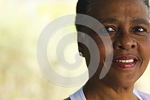 Head of happy african american senior woman smiling in sunny garden, copy space