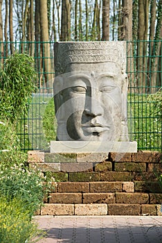 Head of Khmer figurine as a gargoyle for the garden photo