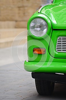 Head light of a East-German plastic vintage car. Green Trabant