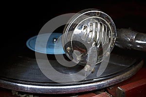 Head with an old gramophone needle on the vinyl disc