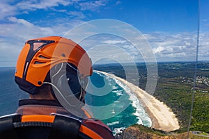 head of a pilot in a Gyrocopter with Wategoes Beach in the background, Byron Bay, Queensland, Australia