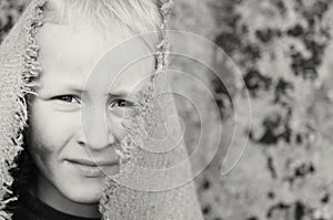 The head portrait of a poor boy. Head in a sackcloth. Emotions.