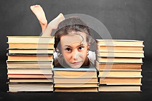 Head of sad teenage girl leaning on old books photo