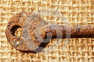 HEAD OF A SEVERELY RUST COATED KEY ON HESSIAN photo