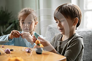 Happy cute small children siblings involved in handmade activity.