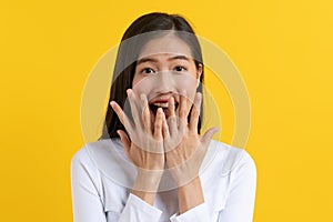 Head shot Beautiful young woman surprised facial expression after seeing shocking, amaze deal isolated on yellow background.