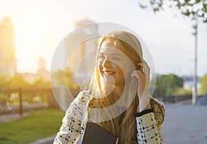 Head shot of blond smiling woman walking on street and dreamy looking aside