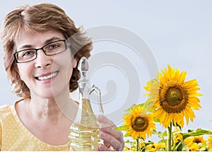 Head shot of caucasian woman holding bottle of sunflower oil