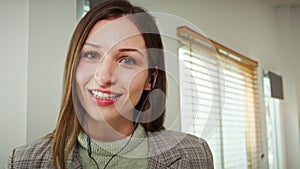 Head shot of cheerful female entrepreneur looking at camera talking on video call in the home office