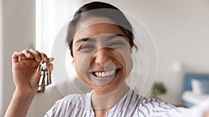 Head shot close up of excited Indian woman showing keys