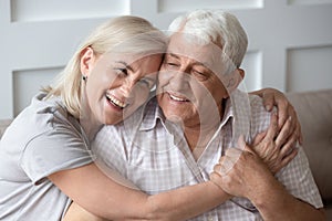 Happy middle aged woman snuggling to smiling older husband.