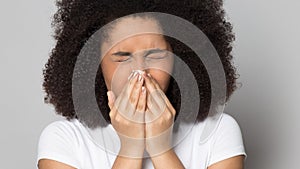 Head shot sick African American girl blowing nose, holding handkerchief