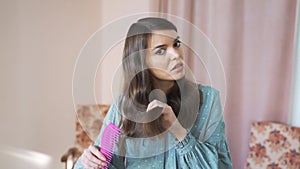 Head shot close up stressed millennial mixed race woman looking at mirror, brushing hair. Irritated annoyed young girl