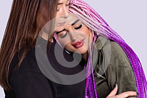 Head shot close up two modern authentic girls cuddling smiling female friend. Overjoyed excited best buddies embracing