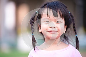 Head shot cute little girl looking at camera with smiling face. Girl labia is dry and chapped lips. photo