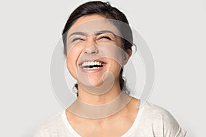Head shot excited Indian young woman laughing out loud
