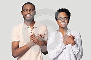 Head shot happy African American couple holding hands on chest