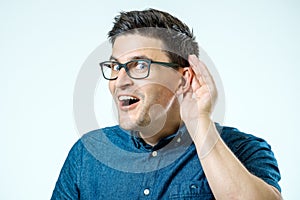 Head shot of man trying listen gossip or news. Isolated on grey