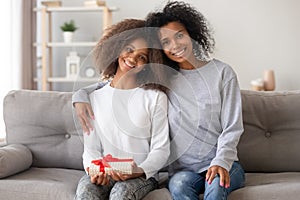 Head shot portrait of African American girl receiving gift from mother