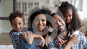 Head shot portrait of African American parents piggy backing kids