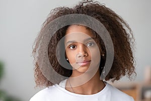 Head shot portrait attractive african teenager girl looking at camera