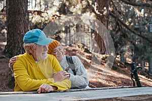 Head shot portrait close up of cute couple of old middle age people having fun and enjoying together in the forest of the mountain