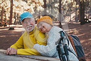 Head shot portrait close up of cute couple of old middle age people having fun and enjoying together in the forest of the mountain