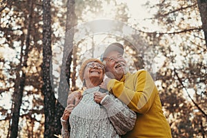 Head shot portrait close up of middle age cheerful people smiling and looking at the the trees of the forest around them. Active