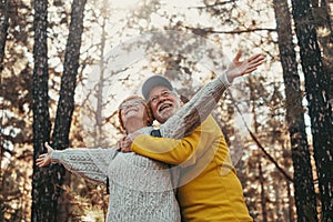 Head shot portrait close up of middle age cheerful people smiling and looking at the the trees of the forest around them. Active