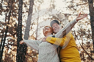 Head shot portrait close up of middle age cheerful people smiling and looking at the the trees of the forest around them. Active