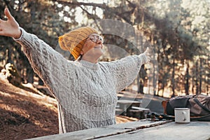 Head shot portrait close up of middle age woman enjoying and relaxing sitting at table in the nature in the forest of mountain.