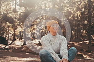 Head shot portrait close up of one middle age old woman resting and relaxing doing yoga in the forest of mountain in the nature.