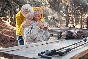 Head shot portrait close up of one middle age woman drinking coffee or tea from a cup sitting at table in the nature in the forest