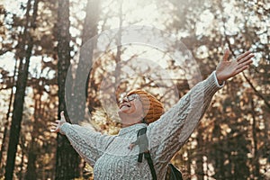 Head shot portrait close up of one middle age woman looking at the trees enjoying nature alone in the forest. Old female with