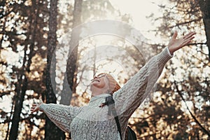 Head shot portrait close up of one middle age woman looking at the trees enjoying nature alone in the forest. Old female with