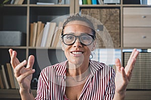 Head shot portrait confident businesswoman coach wearing glasses looking at camera and talking, mentor speaker holding online