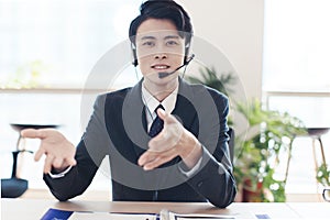 Head shot portrait confident young businessman  looking at camera and talking by headphone