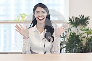 Head shot portrait confident young businesswoman  looking at camera and talking by headphone