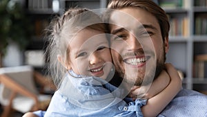 Head shot portrait cute little girl hugging smiling father