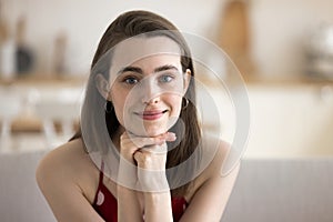 Head shot portrait of cute young woman staring at camera