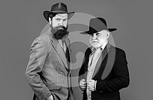 Head shot portrait of elderly mature senior dad and grownup son. Two male generations family. Men in hat. Men in