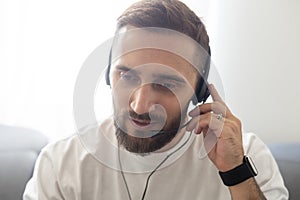 Head shot portrait of handsome smiling man wearing headset at office looking at camera. Call center introduction. Happy